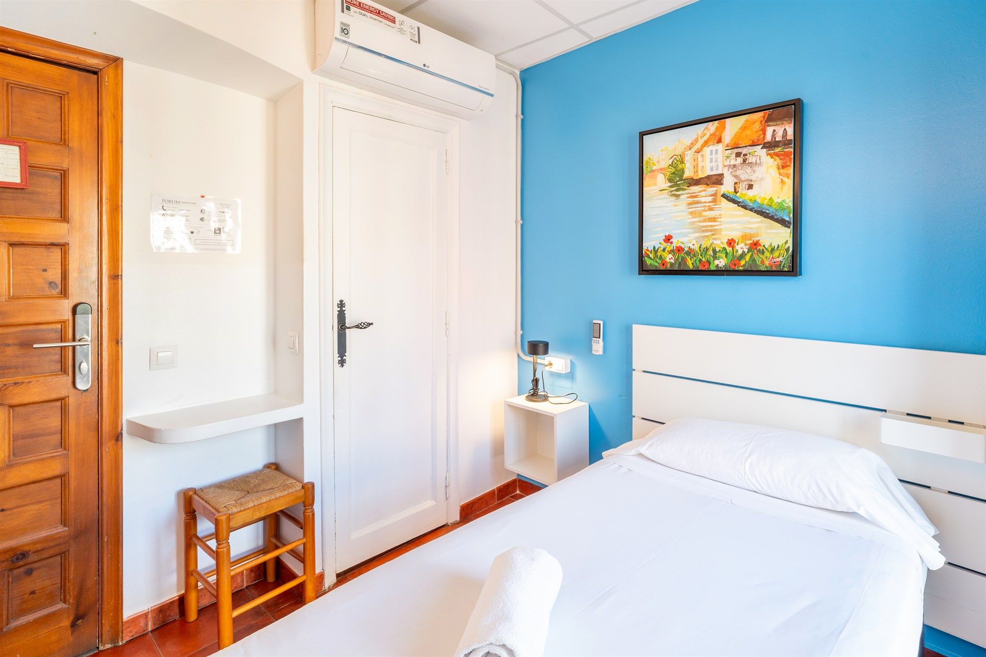 Hay un cuadro en la pared encima de la cama en la habitación.