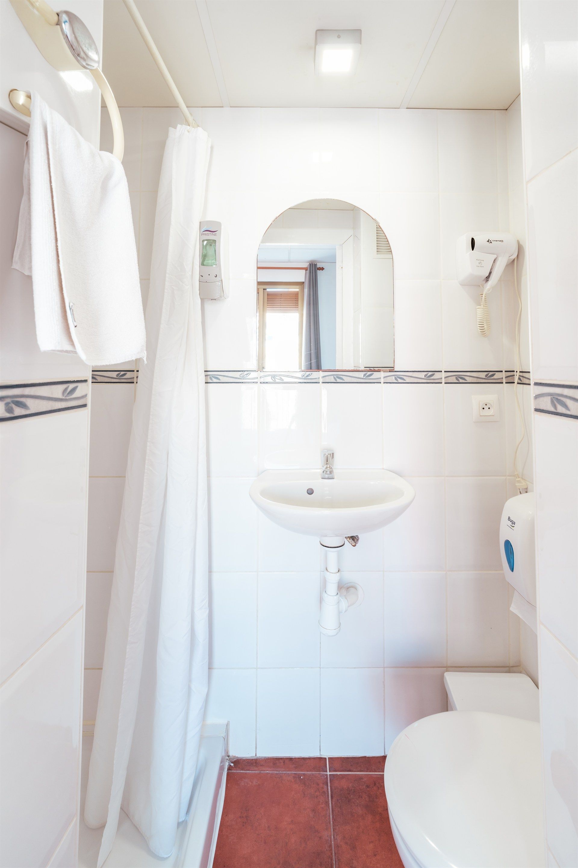 Un baño con lavabo, inodoro y cortina de ducha.