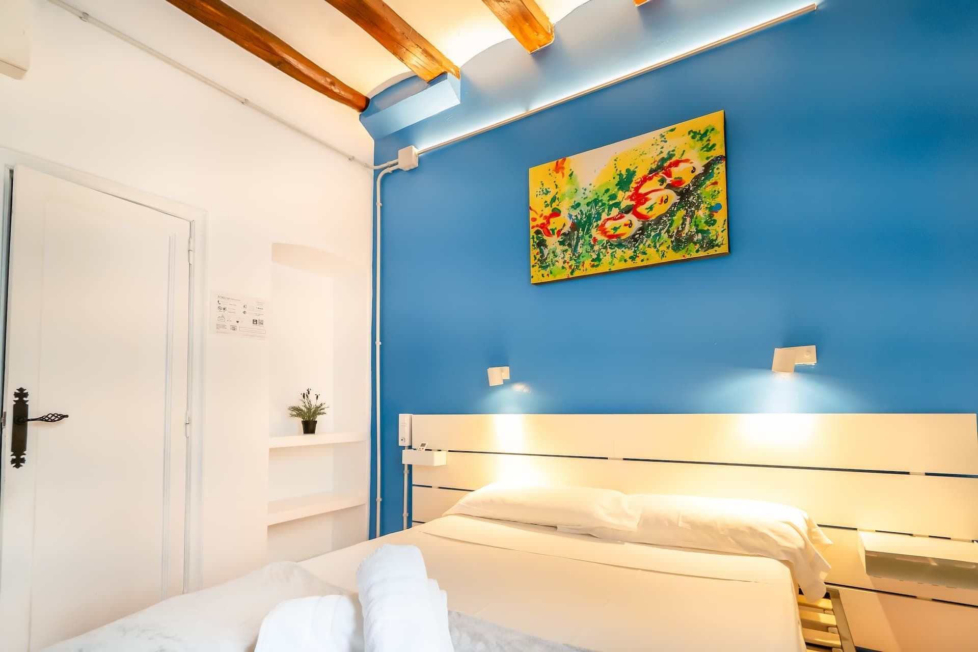 Un dormitorio con una cama y un cuadro en la pared.
