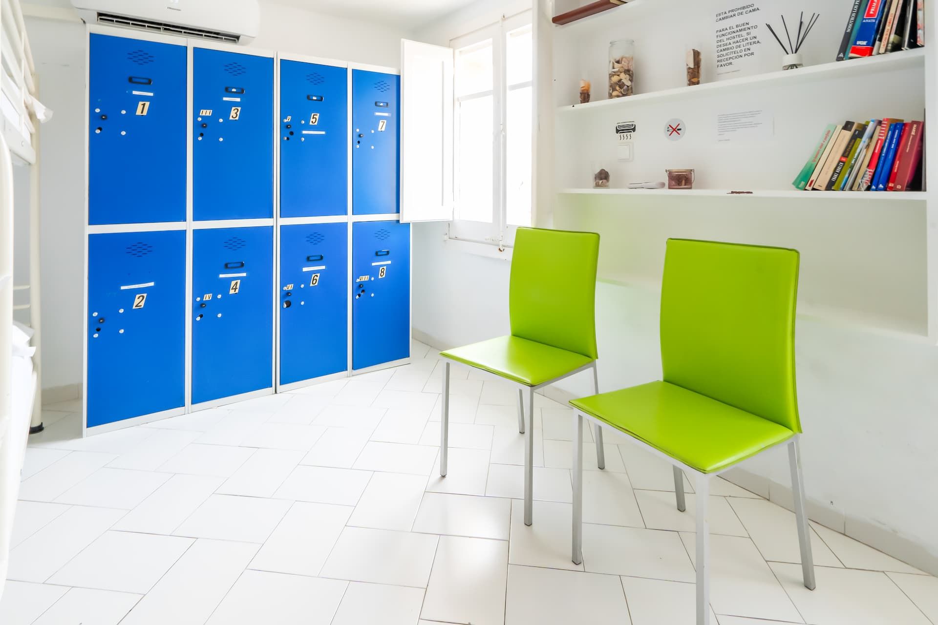 Una habitación con taquillas azules y sillas verdes