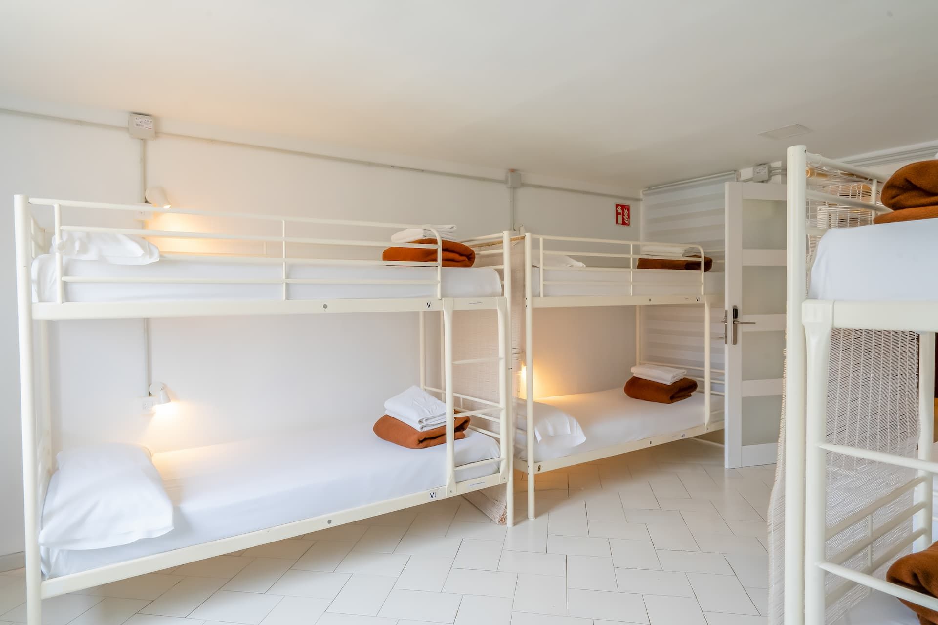 Una habitación llena de literas y una puerta.