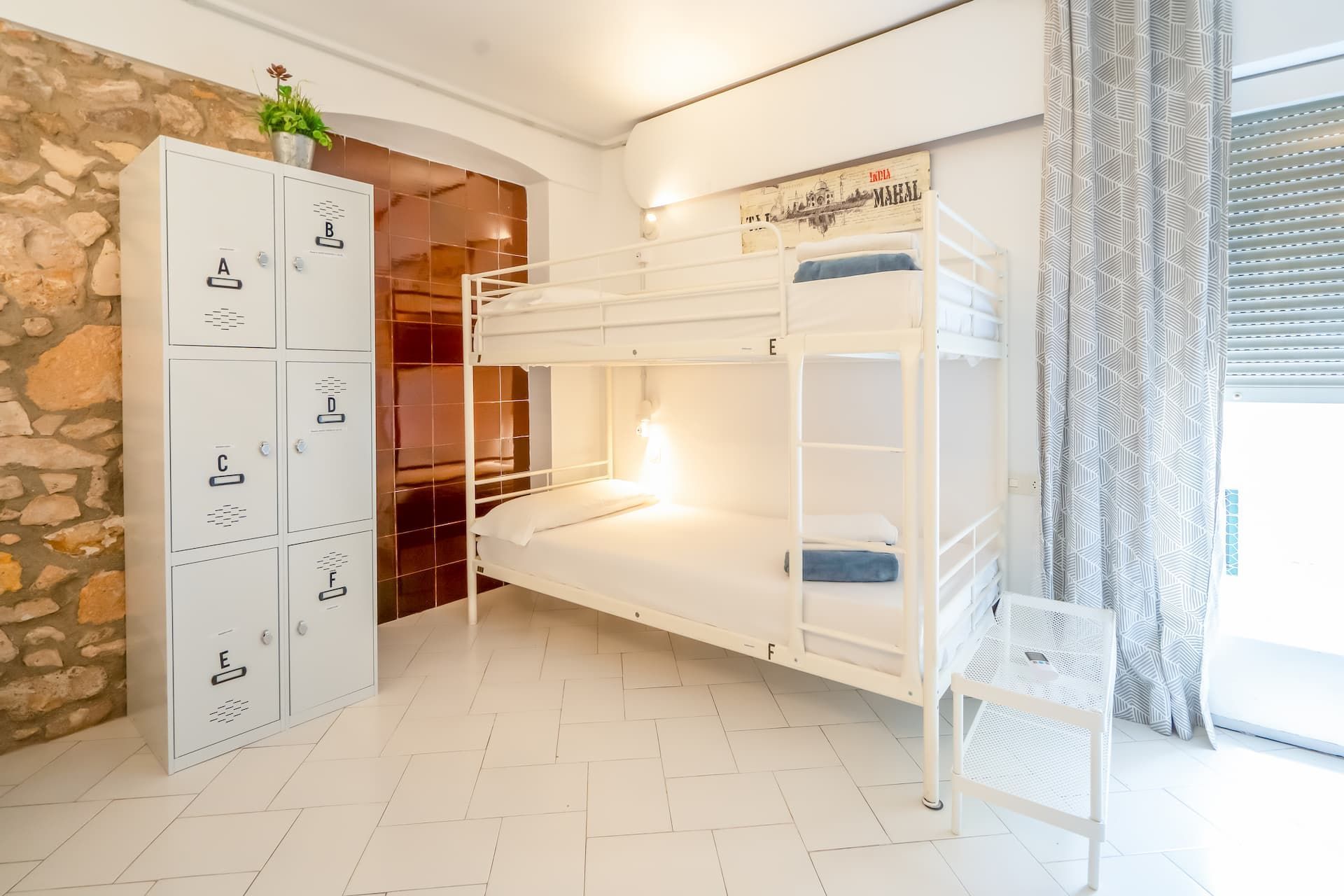 Una litera está ubicada en una habitación al lado de un armario.