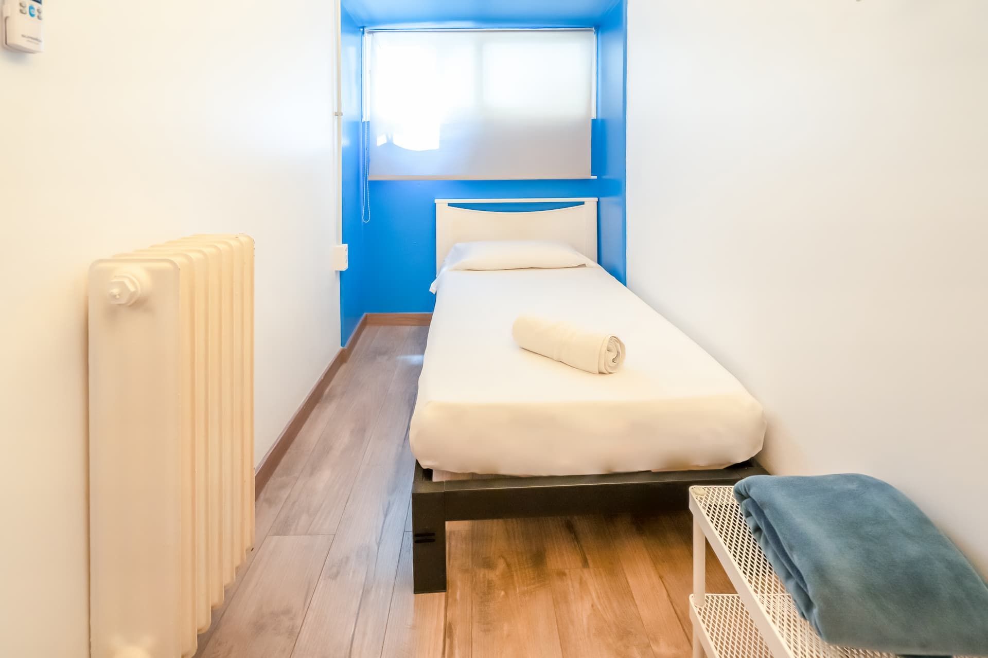 Un dormitorio pequeño con una cama individual y un radiador.
