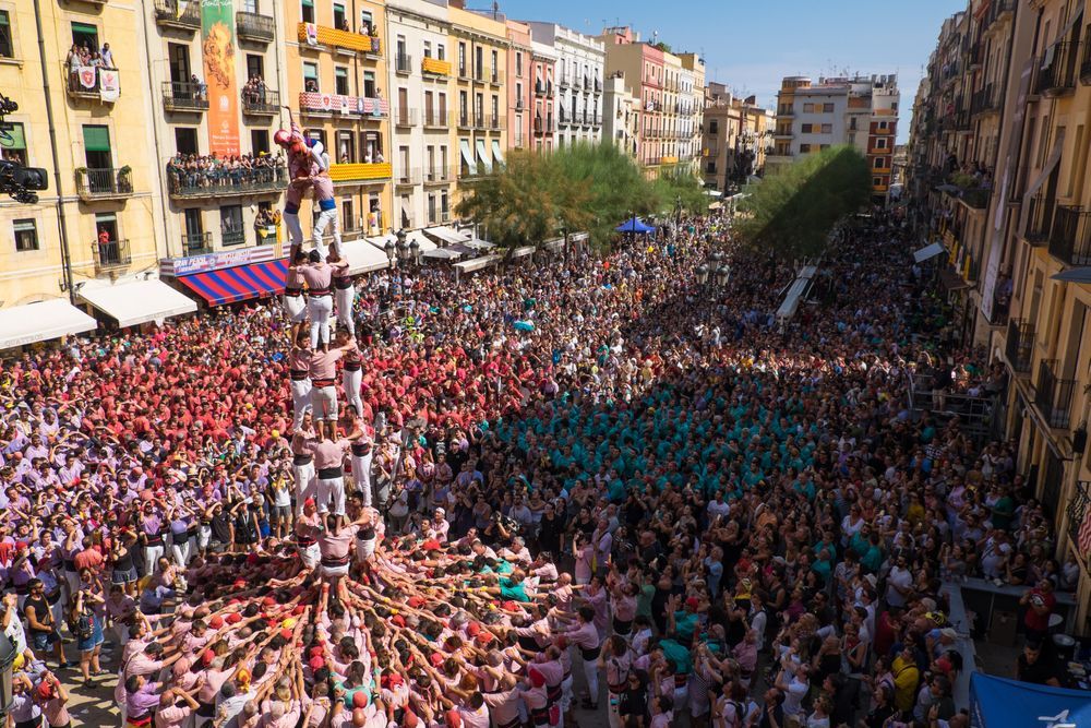 Una gran multitud de personas está reunida en una plaza de la ciudad.