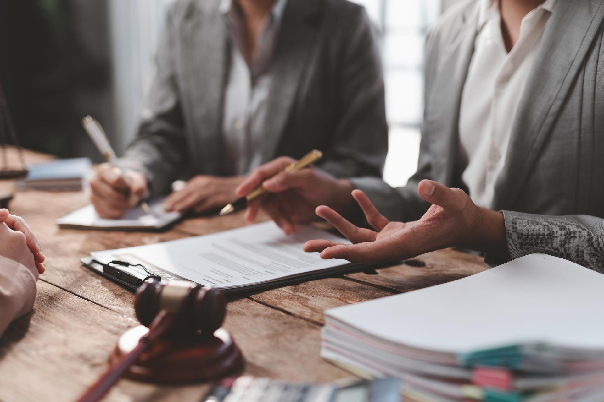 General civil law lawyer discussing a contract with clients in a professional office setting. General civil law lawyer discussing a contract with clients in a professional office setting.