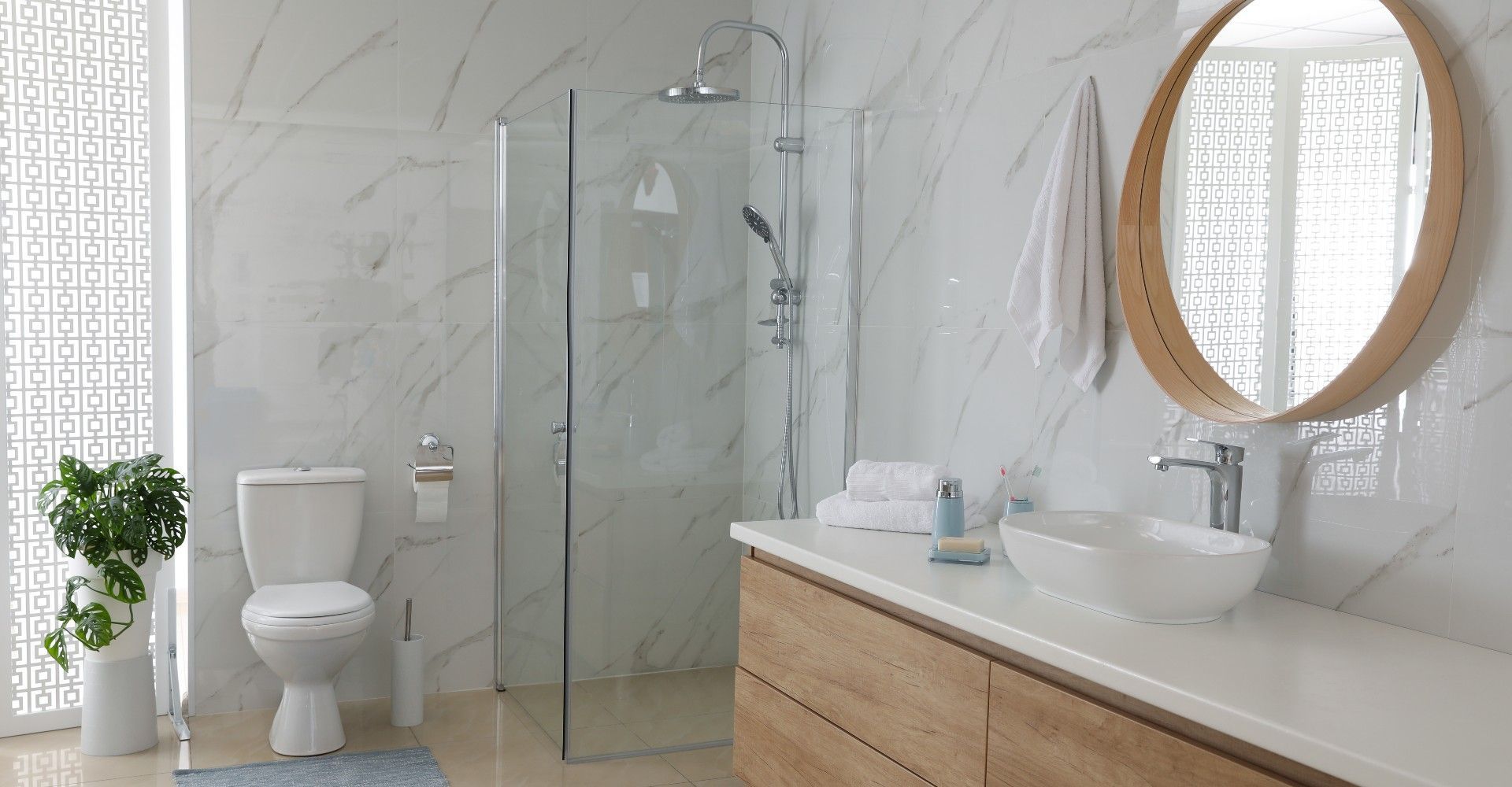 A bathroom with a toilet , sink , shower and mirror.