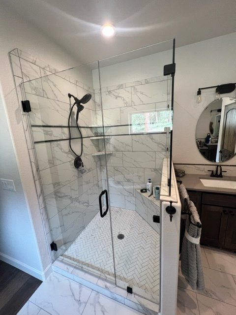 A bathroom with a walk in shower and a sink.