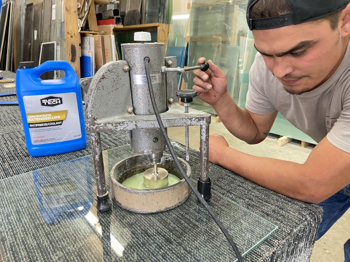 A man is working on a machine next to a bottle of cleaner