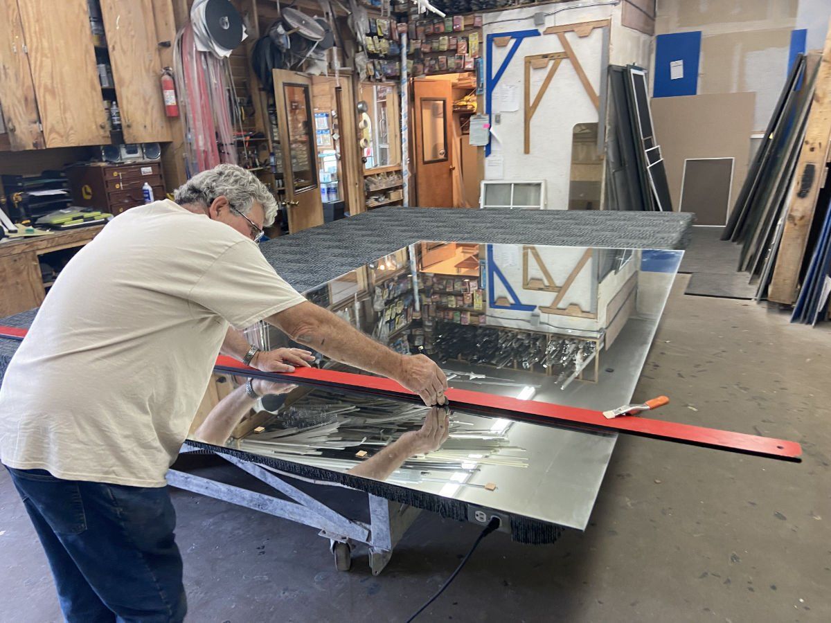 A man is working on a large piece of metal in a workshop.