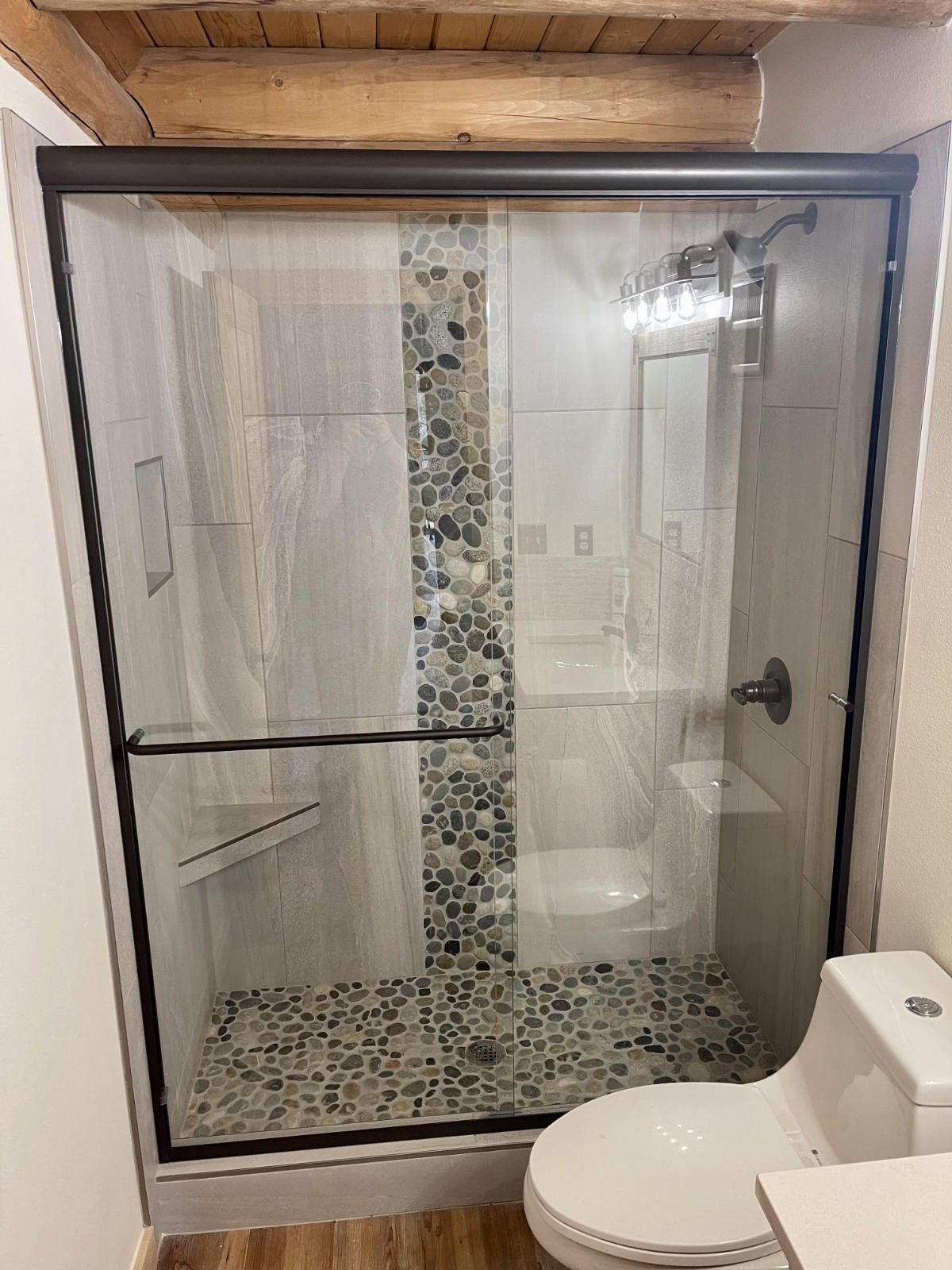 A bathroom with a toilet and a shower with a glass door.