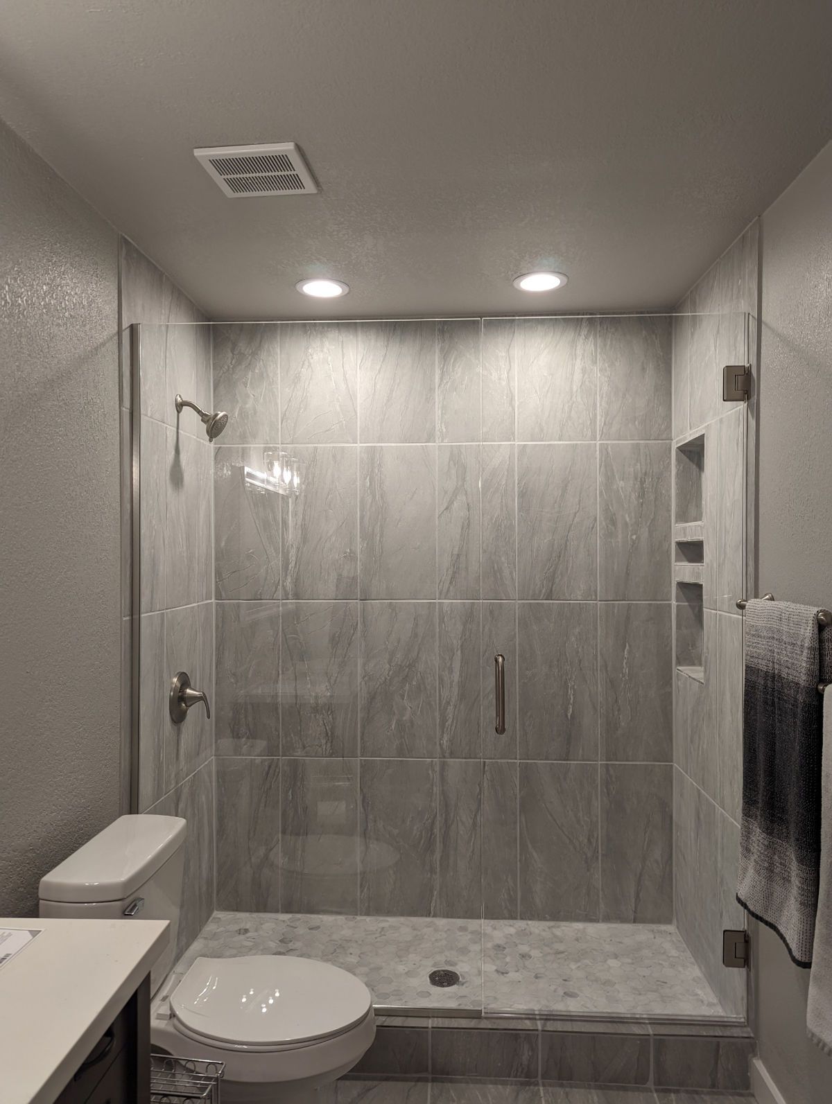 A bathroom with a toilet , sink and shower.