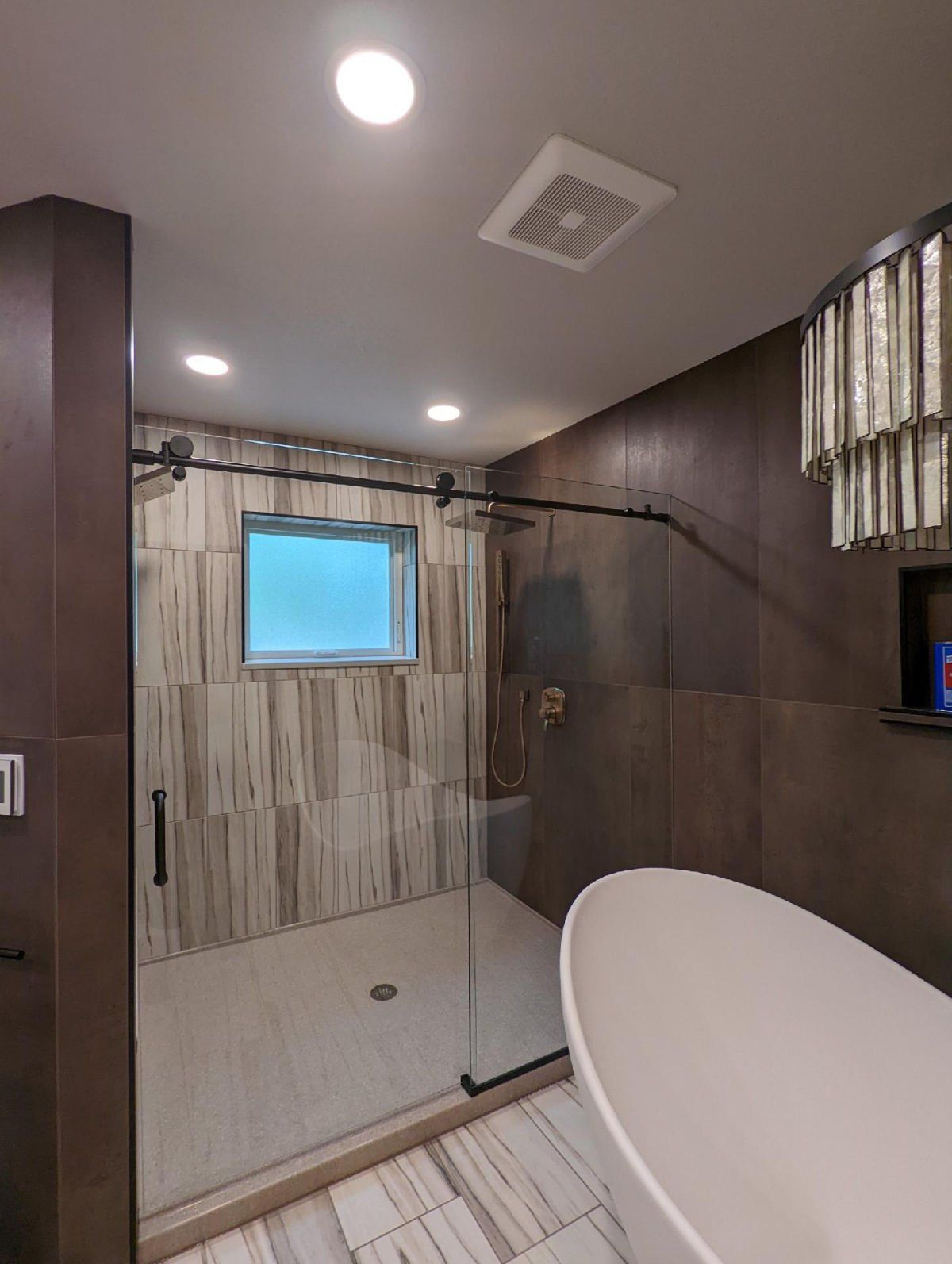 A bathroom with a tub , shower and window