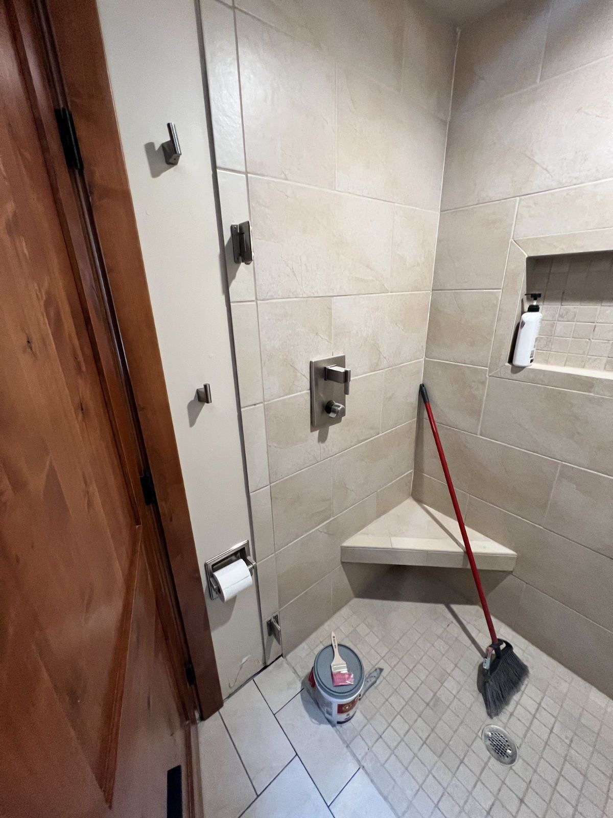 A bathroom with a mop and bucket on the floor