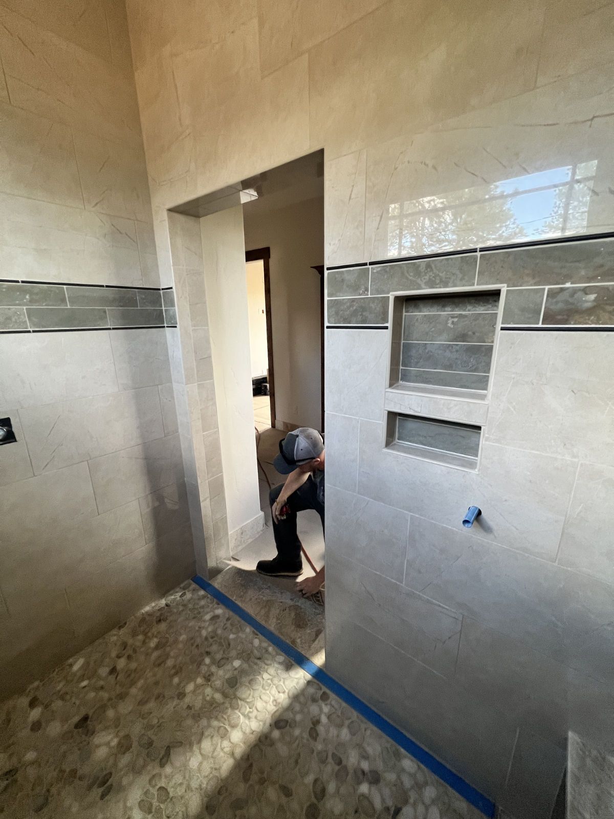 A man is working on a shower in a bathroom.