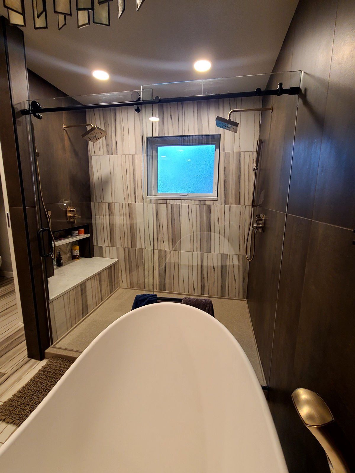 A bathroom with a tub , shower , and window.
