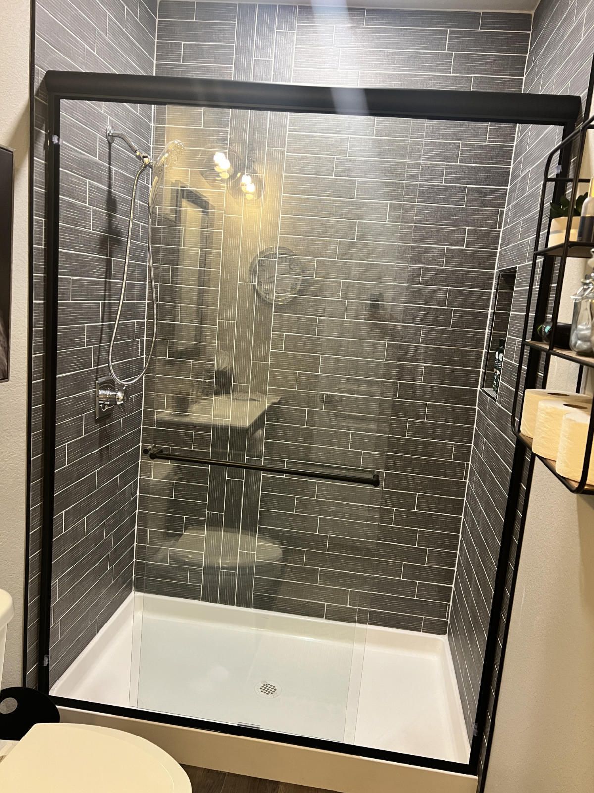 A bathroom with a walk in shower and a toilet.