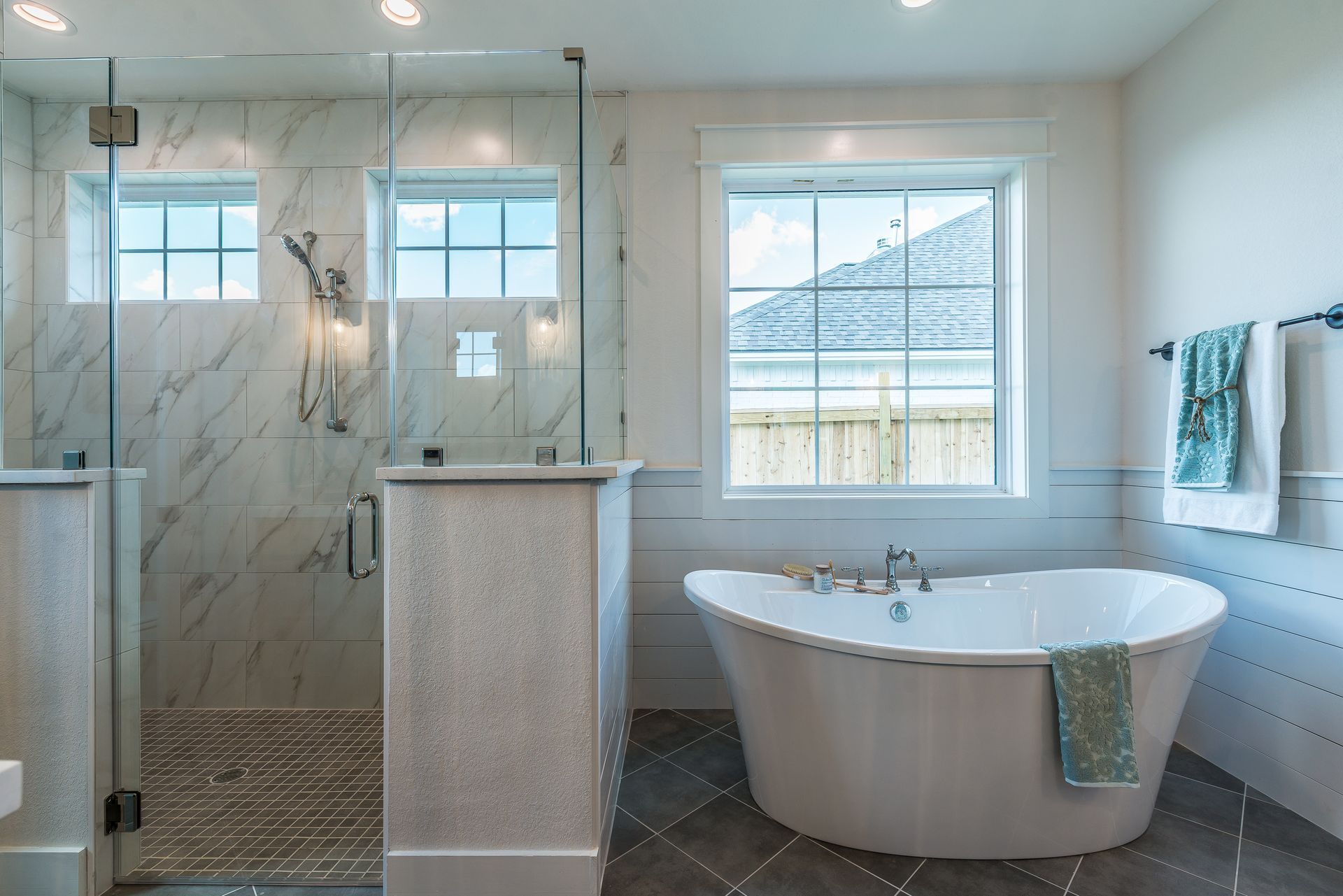 A bathroom with a tub , shower and window.