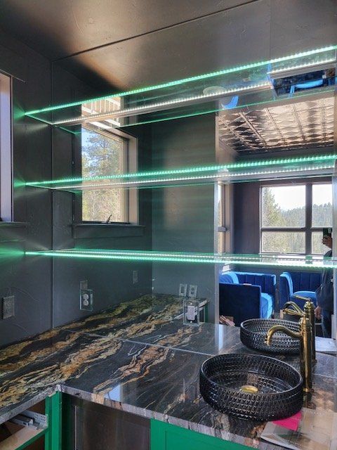 A kitchen with a sink and shelves with green lights.