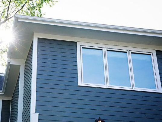 The sun is shining through the windows of a blue house using low e window glass