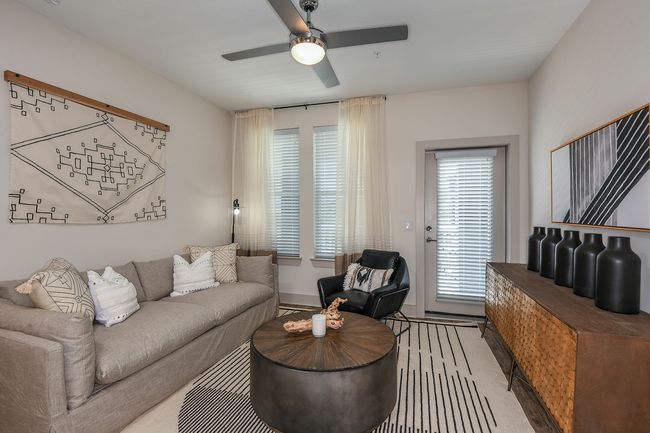 A living room with a couch, chair, coffee table, and ceiling fan at Isla Antigua, which offers apartments for rent in St. Augustine, FL.