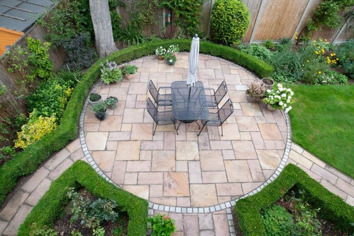 An aerial view of a patio with a table and chairs in a garden.