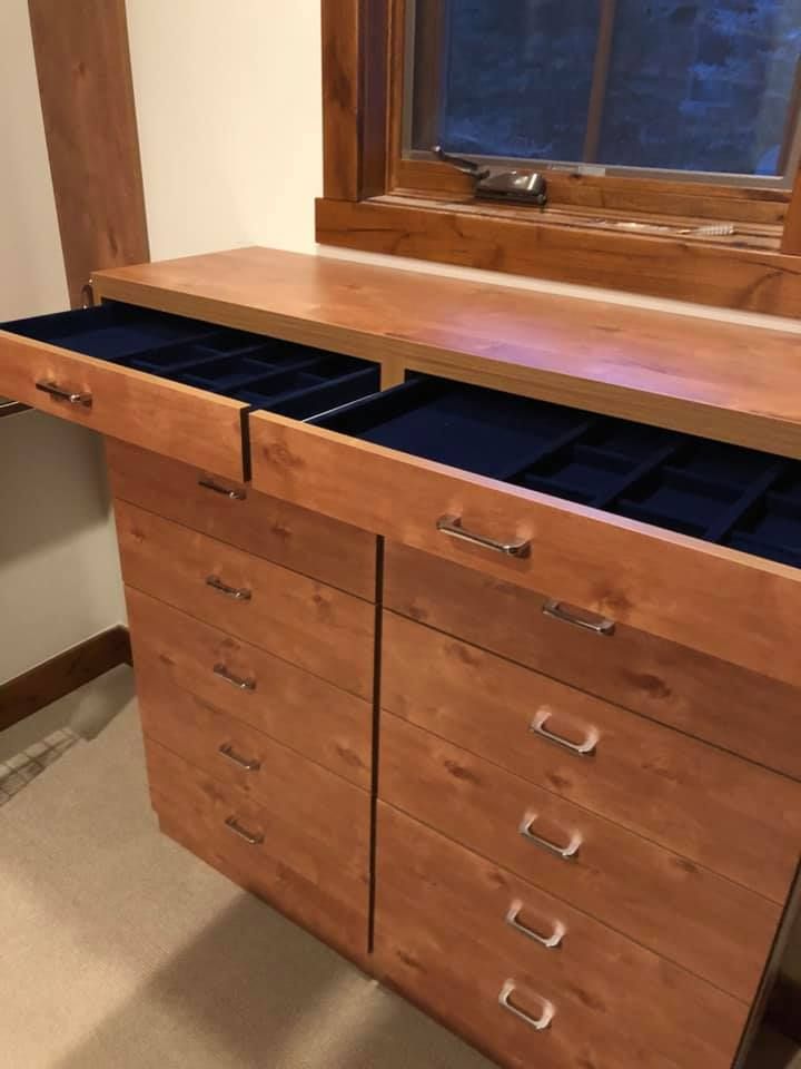Wooden dresser with drawers and built-in countertop under a window, one drawer open showing blue velvet.