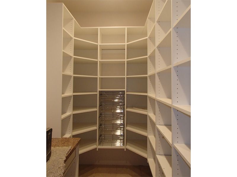 White-shelved pantry with a unique, angled design. Beige floor and countertop visible.