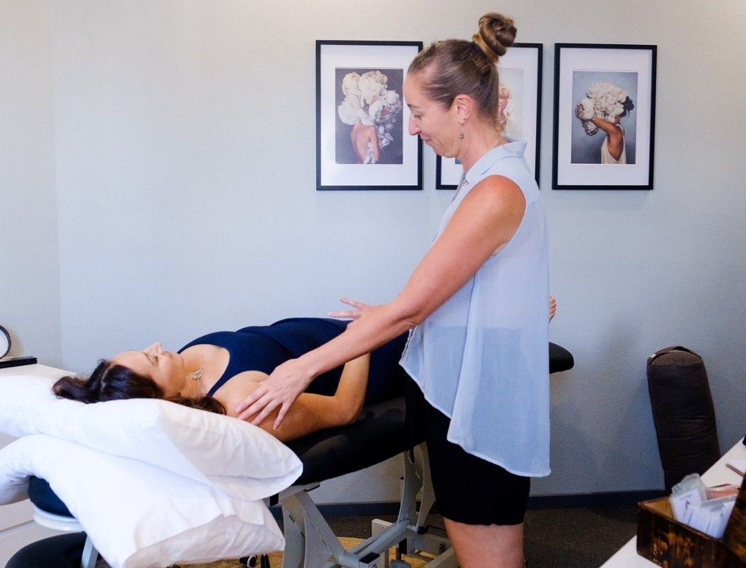 Woman Providing Abdominal Massage to a Person Lying on a Massage Table — The Health Studio Sunshine Coast In Mooloolaba, QLD