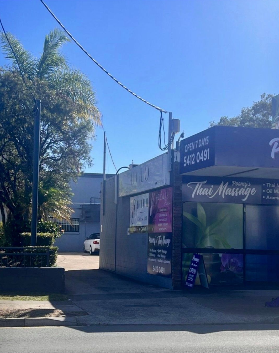 Exterior of a Nutrition Supplements store with a green arrow pointing to the entrance. Yellow and black signage.