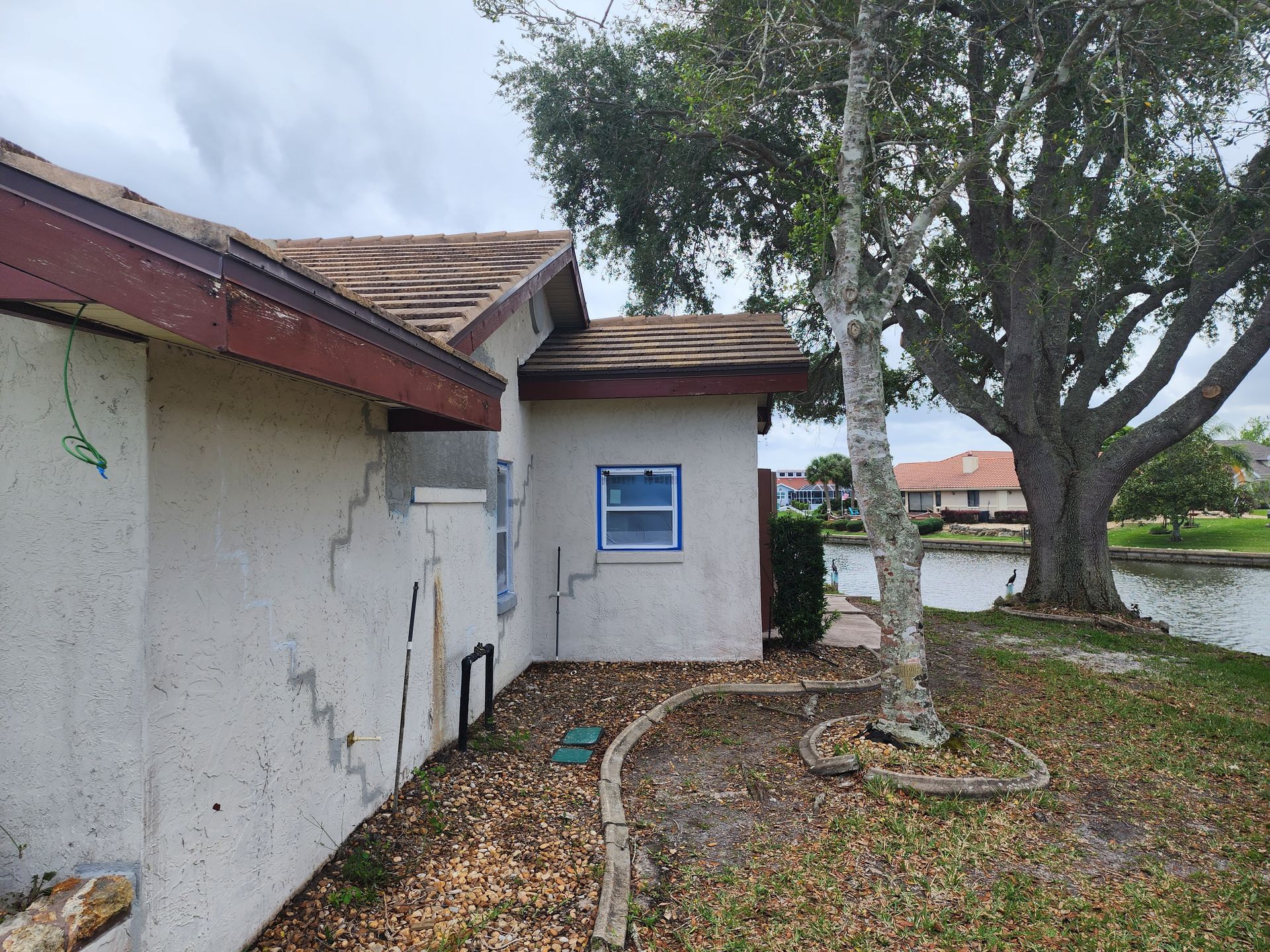 A white house with a tree in front of it.