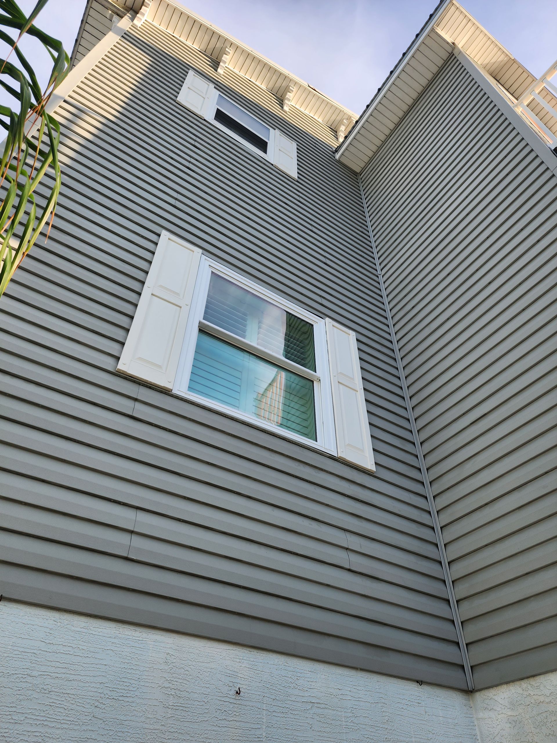 A house with a gray siding and white shutters