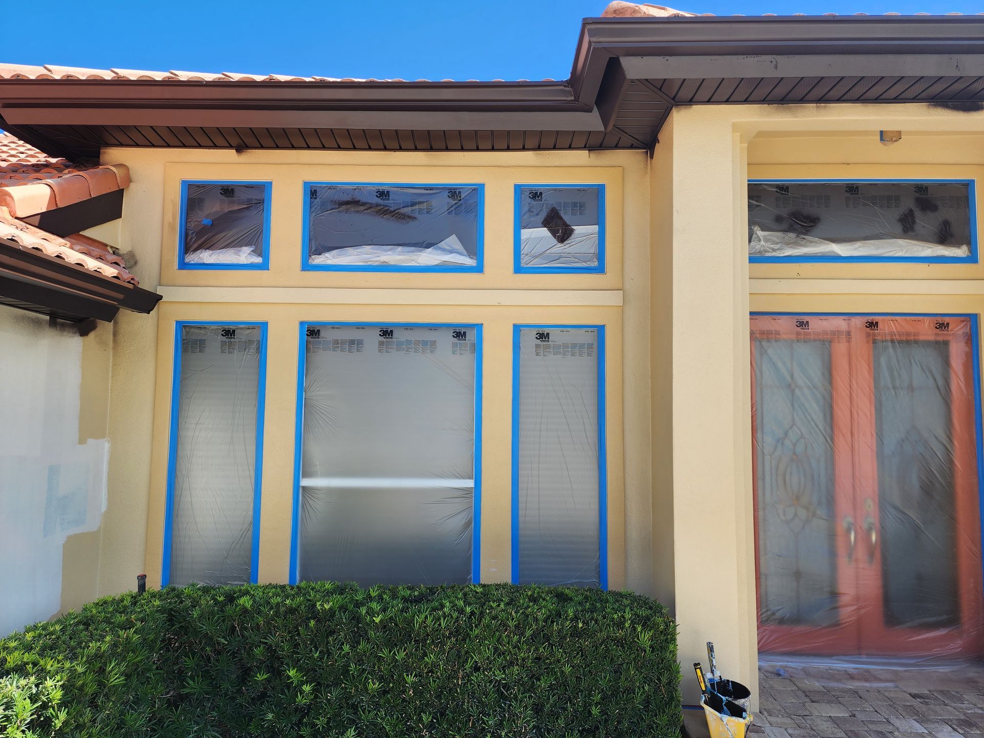 A house with a lot of windows is being painted