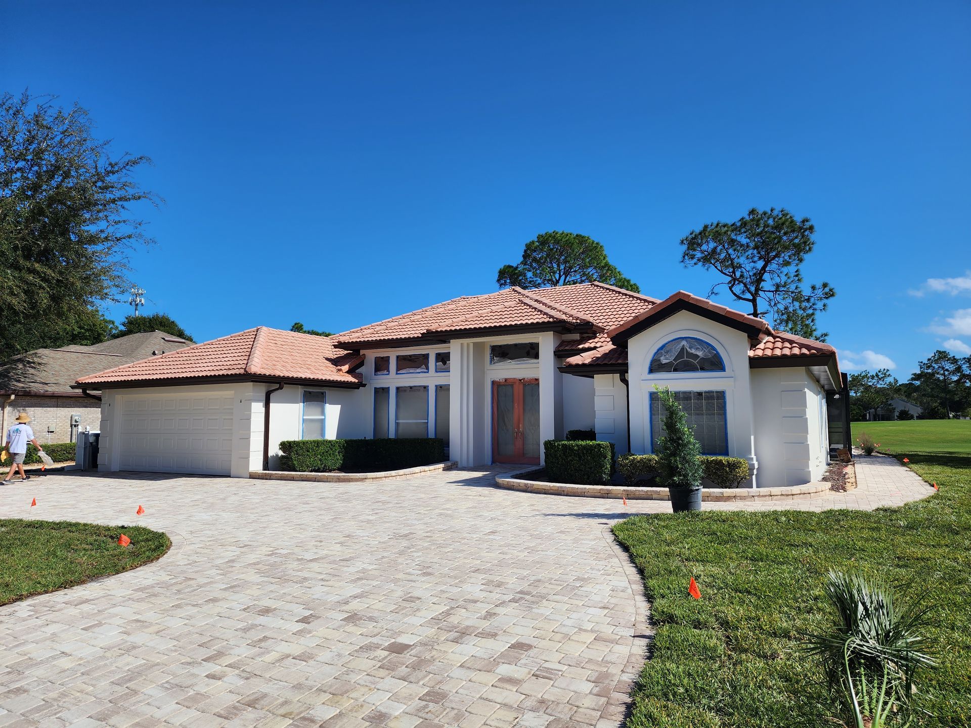 A white house with a tiled roof and a driveway