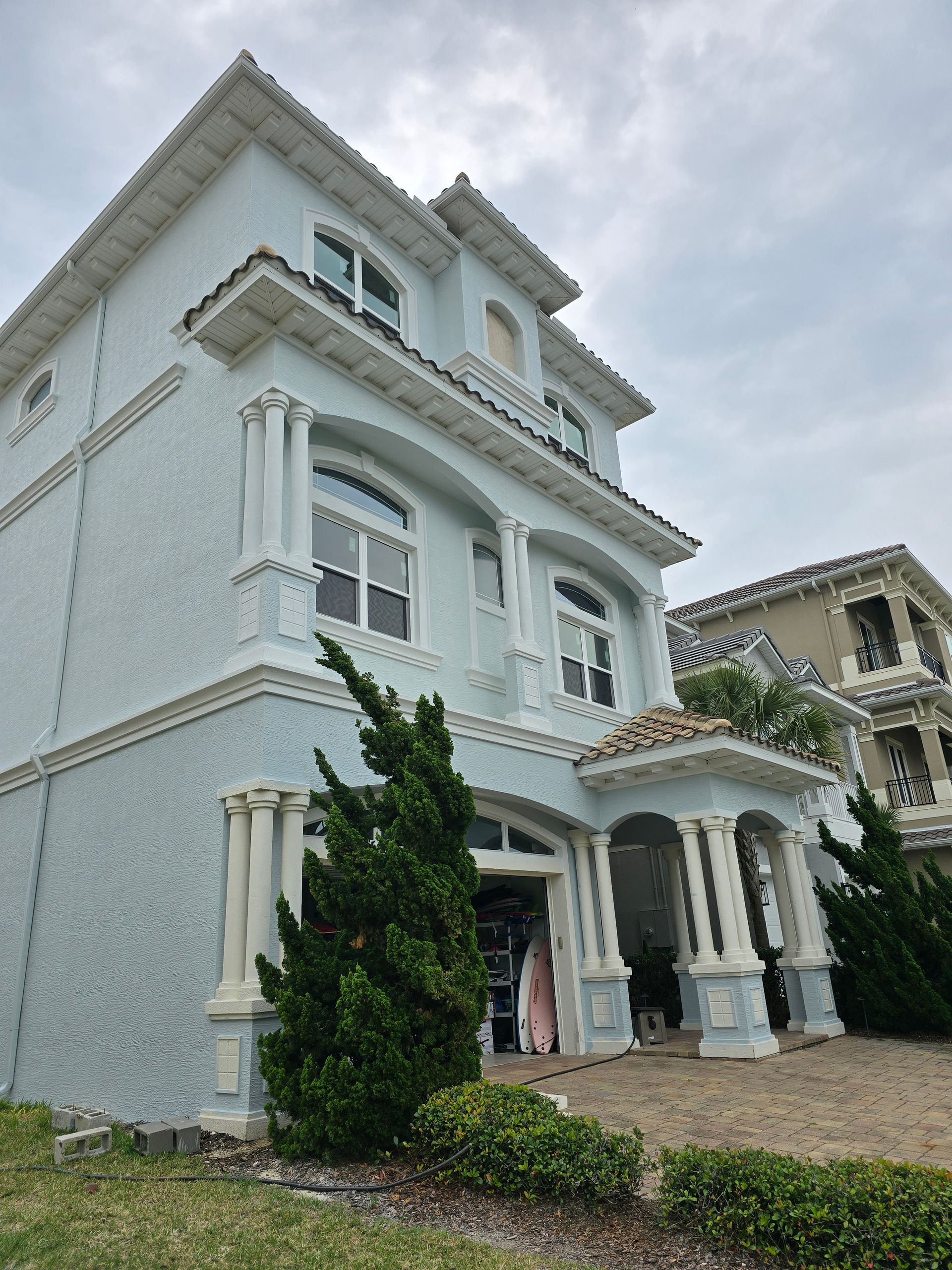 A large blue and white house with a lot of windows.