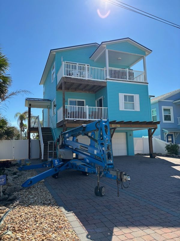 A blue house with a lift in front of it.