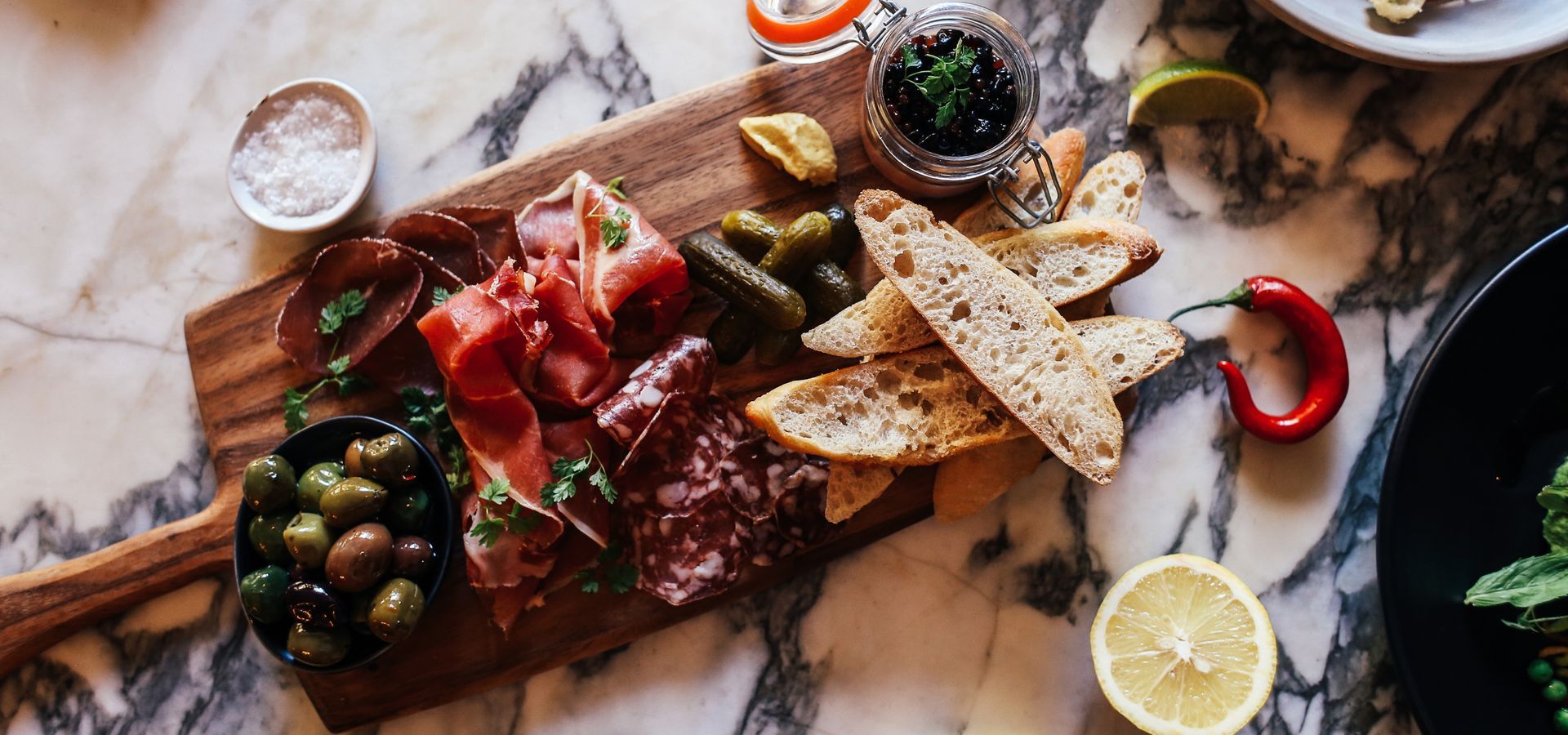 A selection of traditional Portuguese accompaniments: rustic bread, olives, honey, and cured meats—perfect for pairing with wine and cheese.