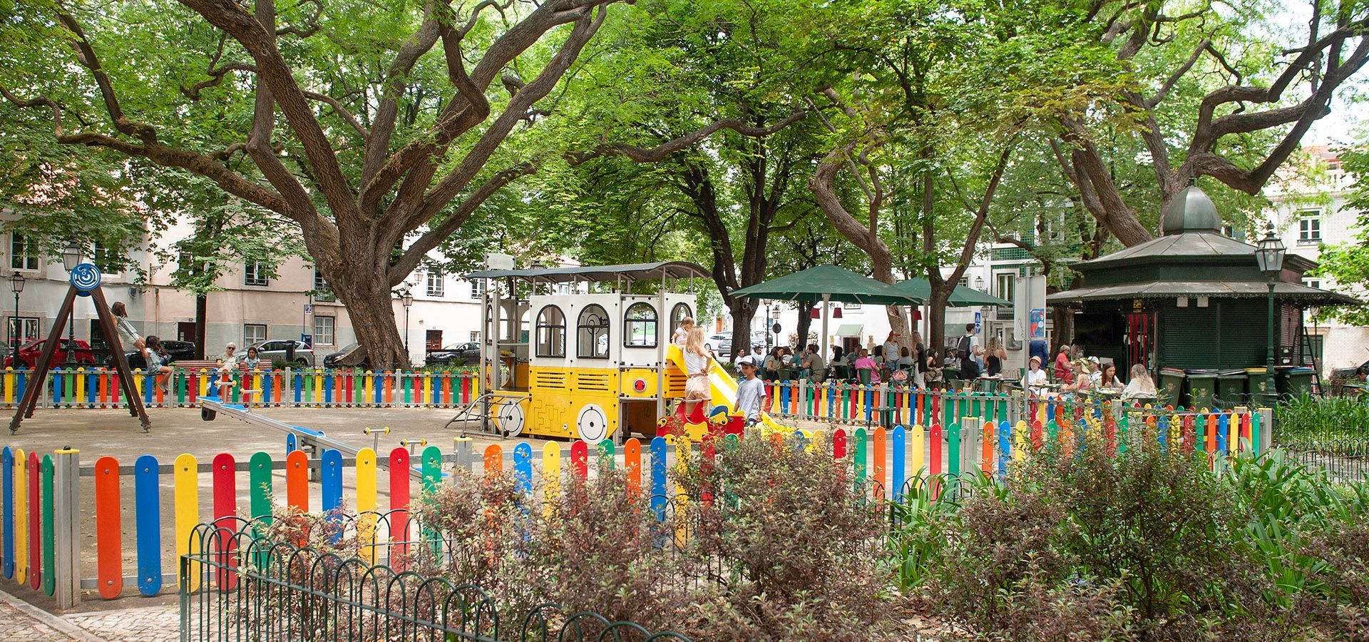 A peaceful garden in Amoreiras, Lisbon, shaded by mulberry trees with a charming fountain at its center.