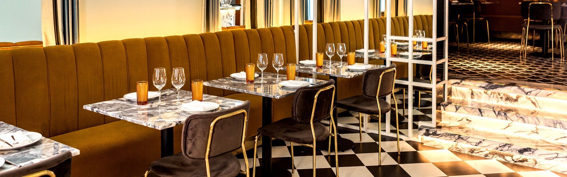 A restaurant with tables and chairs and a checkered floor. Drogaria Restaurant, near Cheese & Wine Lapa