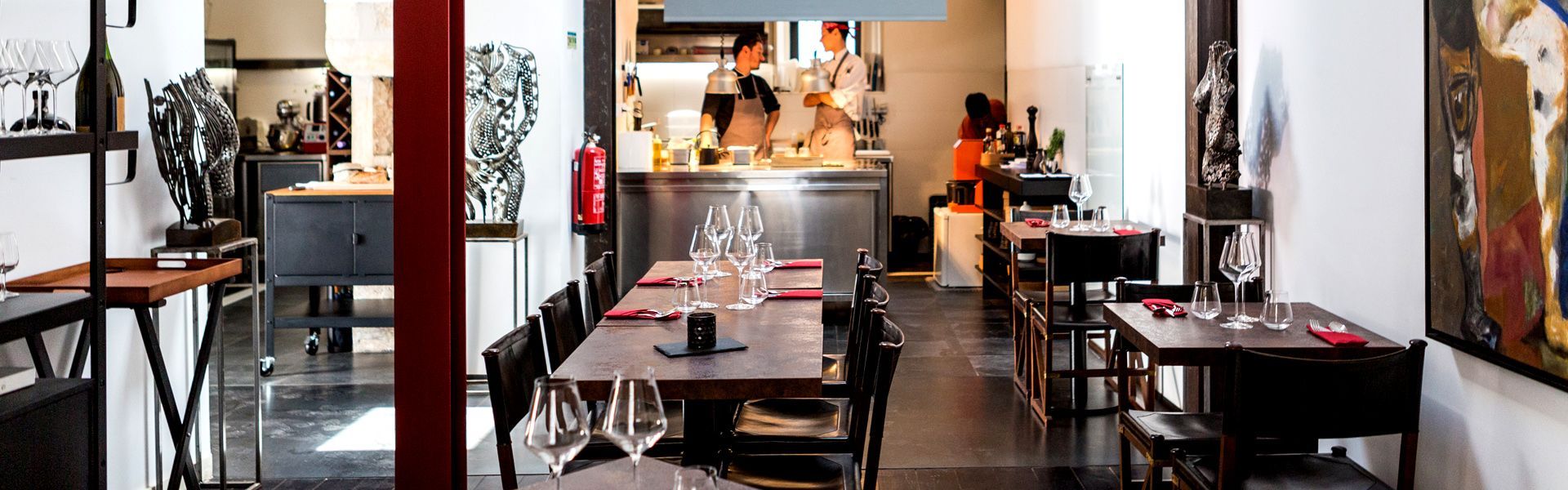 A restaurant with tables and chairs and a fire extinguisher on the wall.