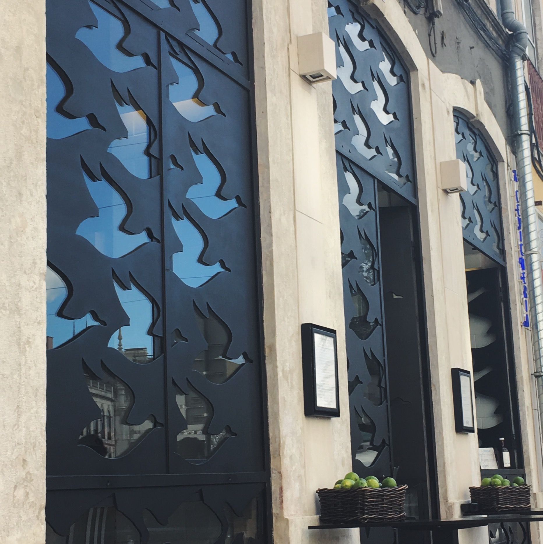 A building with a blue and white pattern on the windows. Front of Cevicheria Restaurant in Principe Real, Lisbon.