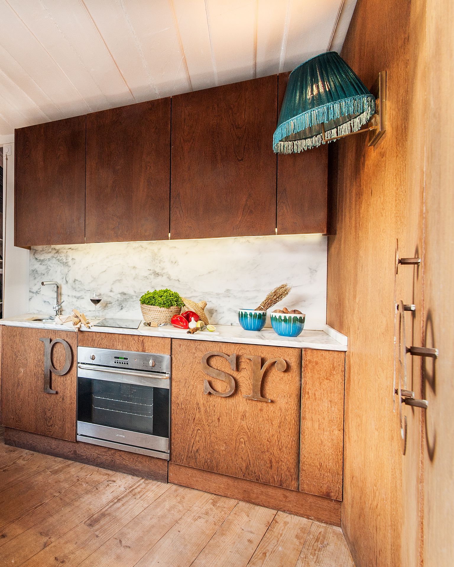 A kitchen with wooden cabinets and a stainless steel oven. Alfama| Cheese & Wine Apartments