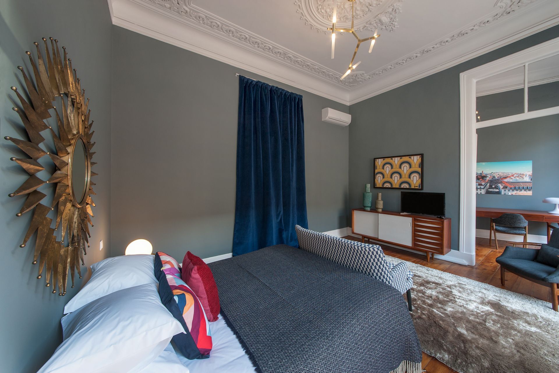 There is a large bed in the middle of the room. Designed by Cheese & Wine Suites.