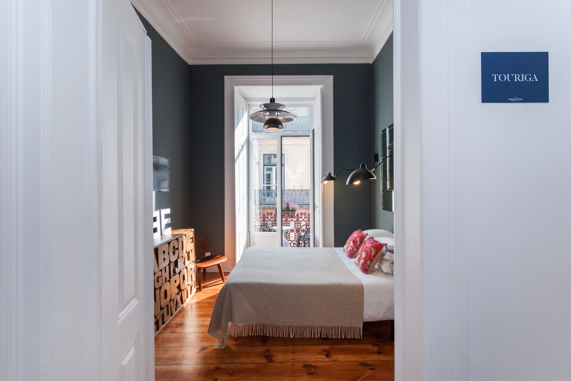 A bedroom with a bed , window and Balcony at Cheese & Wine Suites.