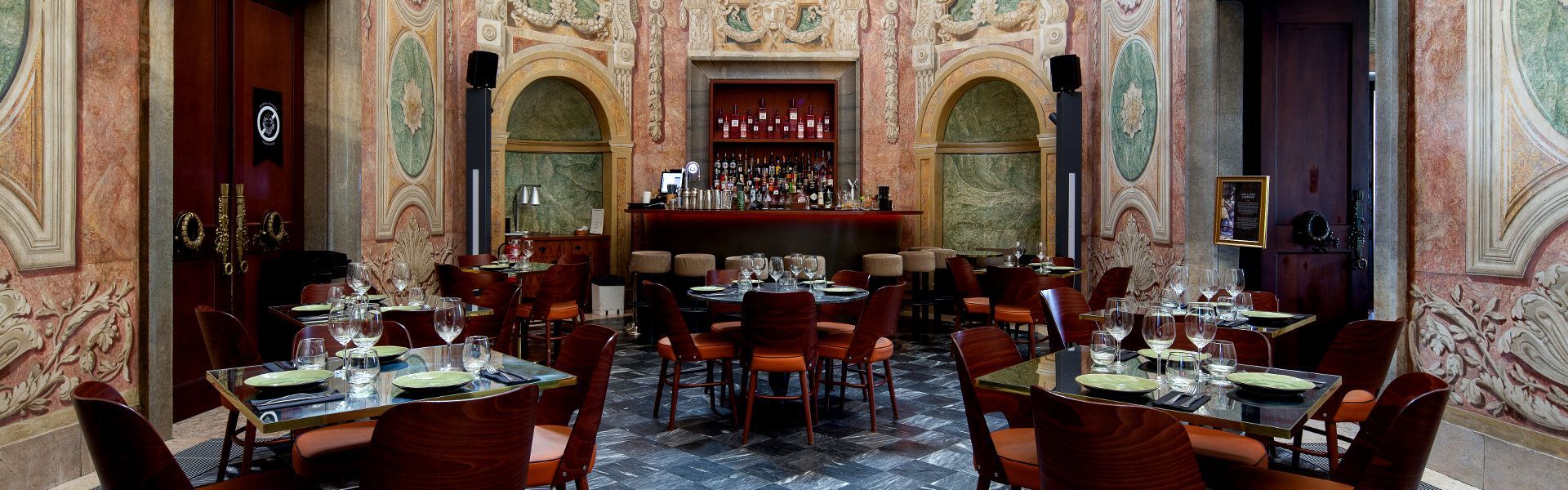 A large room with tables and chairs and a fireplace.
