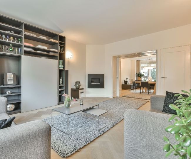 A living room with a couch , chair , coffee table and rug.