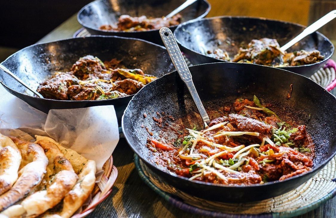 A table topped with bowls of food and bread.