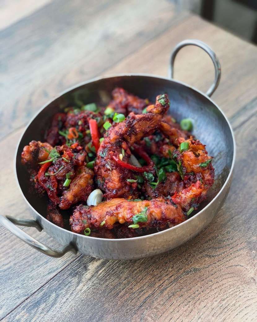 A bowl of food is sitting on a wooden table.