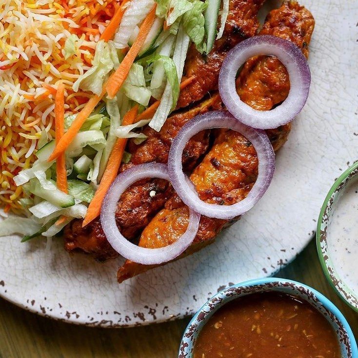 A plate of food with onions carrots and rice