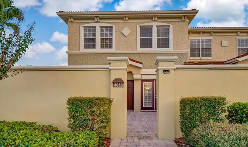 A large house with a fence around it and a doorway leading to it.