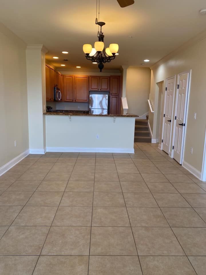 An empty kitchen with a chandelier hanging from the ceiling